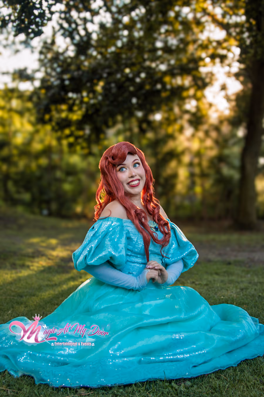 Ariel in her teal gown seated on the grass at golden hour | Magic At My Door