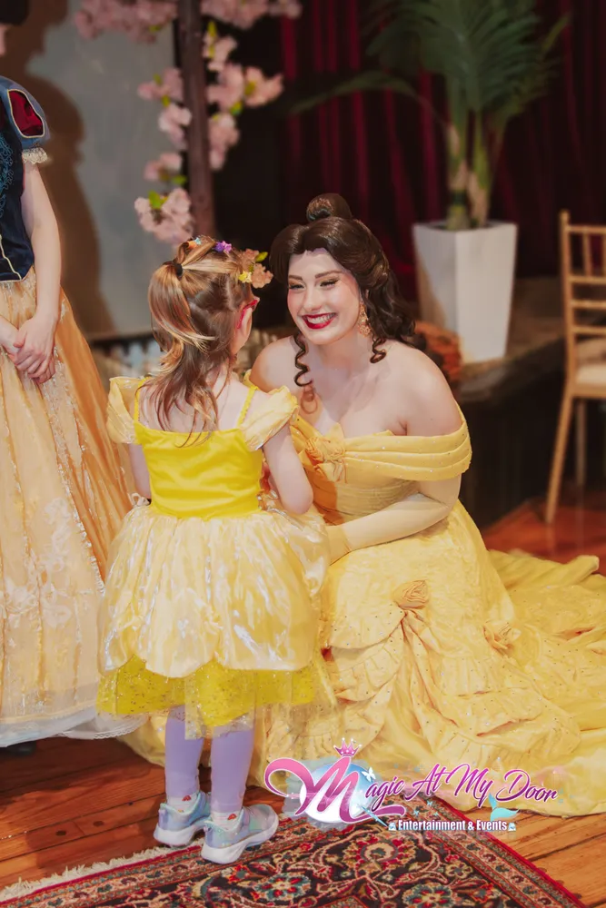 Belle greeting a young girl wearing a matching Belle dress